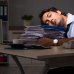 man sleeping on work files